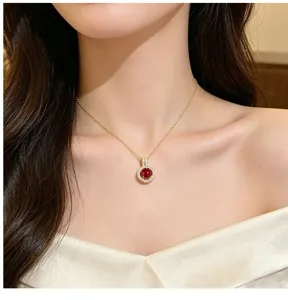 Detailed close-up shot of a red zircon halo pendant necklace on a delicate gold chain.