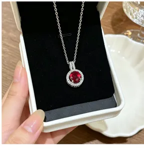 Stunning red crystal halo pendant necklace detail, sparkling zircon stones set in silver chain.