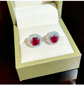 Detailed close-up of shiny red crystal halo stud earrings sparkling beautifully inside gift box.