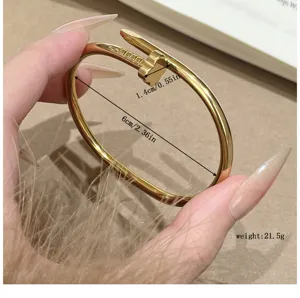 Gold titanium steel nail bracelet with clover motif, stylish cuff bangle for daily wear.