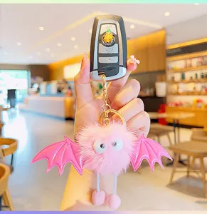 Cute fluffy pink bat plush keychain with devil wings, perfect bag charm and car key accessory.
