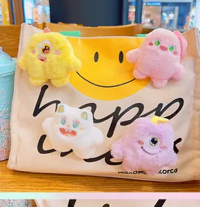 Gedetailleerd overzicht van kleurrijke pluche monster broches weergegeven op een canvas tas.