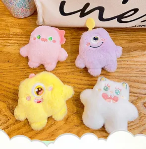 Detailopname van schattige mini pluche monster hangers, zachte pluizige tasaccessoires.