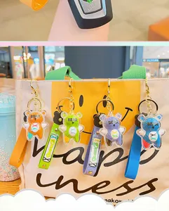 Close-up detail van schattige cartoon beer sleutelhangers met kleurrijke bandjes en ringen.