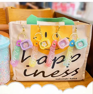 Cute mini glowing TV keychain pendant for bags and car keys, creative cartoon doll accessory.