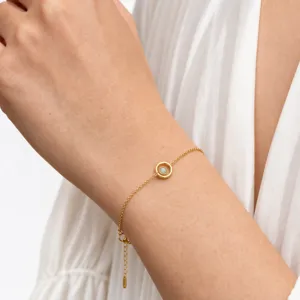 Dainty gold chain bracelet detail showing minimalist circular pendant and secure clasp.
