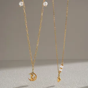 Detail shot of two chic gold plated necklaces featuring cute cat moon and pearl pendants.