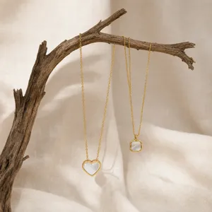 Close-up detail shot of exquisite gold-plated heart and square pendant necklaces on display.