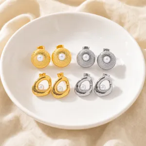 Close-up detail shot of exquisite gold and silver pearl stud earrings set in white plate.