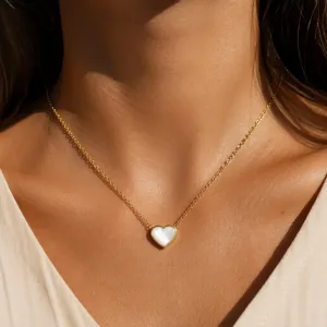 Detailed shot of gold-plated titanium steel necklace with white mother-of-pearl heart.