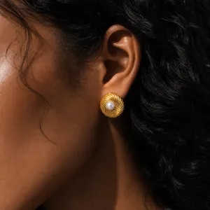 Detailed shot of a vintage gold swirled pearl stud earring worn on the ear, elegant and chic.