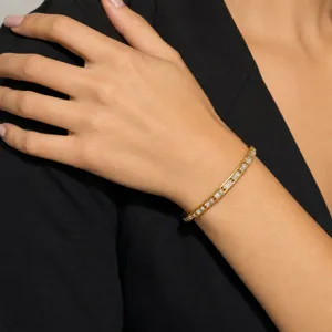 Close-up detail shot of a gold-plated baguette cubic zirconia channel set bangle bracelet.