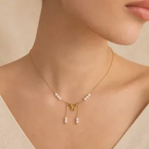 Elegante collana con ciondolo a farfalla placcata in oro con perle delicate.