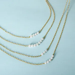 Gedetailleerd overzicht van de meerlaagse goudkleurige ketting met elegante zoetwaterparels.