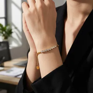 Primer plano detallado de una pulsera de acero inoxidable dorada con brillantes circonitas.
