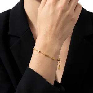 Elegante pulsera de cadena chapada en oro delicada con cuentas cuadradas geométricas.