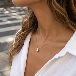 Elegante collar de cadena dorada con un impresionante colgante de cristal en gota.