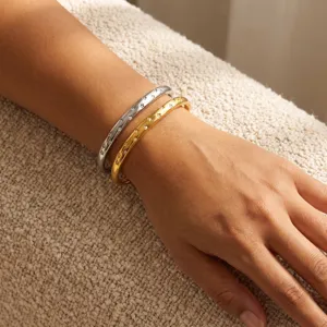 Primo piano di eleganti bracciali bicolore in acciaio al titanio con zirconi al polso.