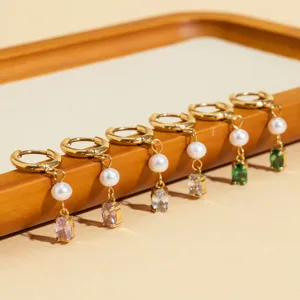 Detailed view of fashionable stainless steel hoop earrings with freshwater pearls and colorful zircon pendants.