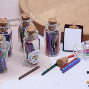 Détail en gros plan de crayons de couleur miniatures en flacons de verre pour décors de poupée.