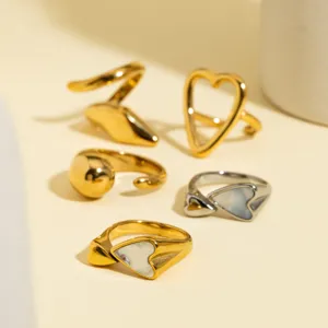 Detailopname van trendy roestvrijstalen geometrische ringen met hart- en slangvormen.