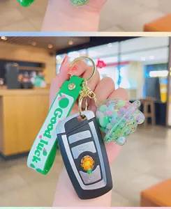 Green liquid glitter floating keychain pendant detail, cute bag charm and key ring accessory.