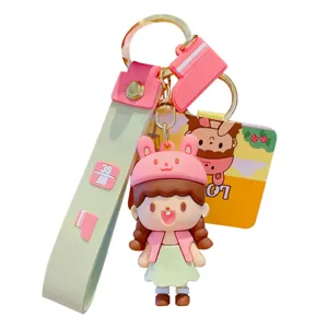 Adorable porte-clés poupée fille dessin animé avec lanière verte et anneau métal pour sac.