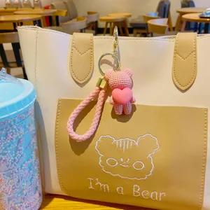 Cute pink woven bear keychain with heart pendant, sweet bag charm accessory for daily use.