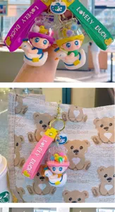 Cute cartoon duck boy keychain detail view featuring a clear capsule design and strap.