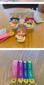 Cute PVC space capsule duck keychain with colorful strap, ideal gift and car key accessory.