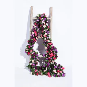 Artificial rose vine garland detail view, vibrant floral decoration for wedding and home decor.