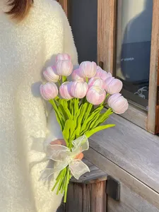 Primer plano detallado del ramo de tulipanes artificiales rosas con tallos verdes y lazo.