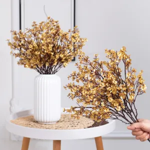 Gold artificial baby breath flowers bouquet with white ceramic vase for home decor party.