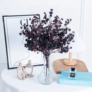 Artificial baby's breath flowers in glass vase, elegant floral table centerpiece.
