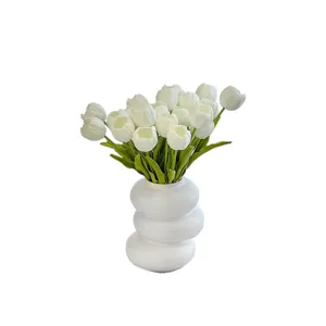 Elegante ramo de flores de tulipanes blancos artificiales en florero de cerámica moderno.