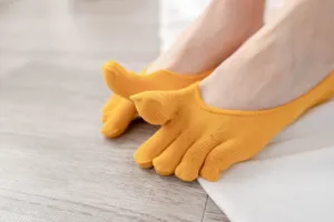 Close-up detail of women's yellow five-toe socks, showcasing breathable cotton and soft toe separation.