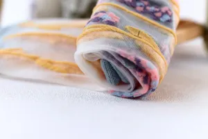 Sheer glass silk socks close up detail view showcasing delicate floral patterns and stripes.