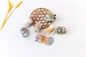 Close-up details of sheer floral summer socks displayed on a woven mat with wheat decor.