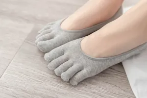Close-up of comfortable grey five toe invisible socks, soft cotton fabric, toe separation detail.