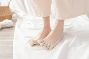 Close-up detail of women's beige five-toe invisible socks, pure cotton soft breathable material.
