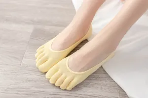 Close-up detail of women's yellow five-toe invisible boat socks, soft cotton comfort.