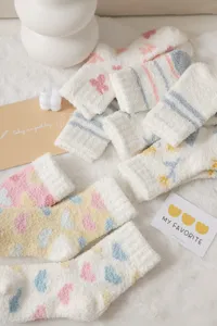 Detailed close-up of fluffy coral fleece cozy winter socks featuring cute patterns.