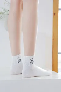 Detail shot of cute white cotton short socks featuring minimalist bear embroidery design.