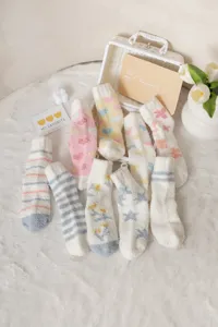 Cozy fuzzy socks details showing soft coral fleece material with cute heart and stripe patterns.