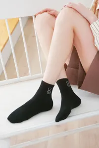Detail view of women's black short socks featuring cute bear embroidery, soft cotton style.