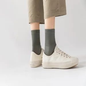 Cómodos calcetines de algodón de tubo medio para hombre combinados con elegantes zapatillas.