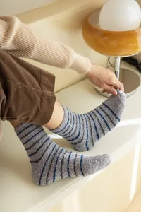 Close-up detail of cozy thick striped coral fleece sleep socks, soft plush texture for warm indoor.