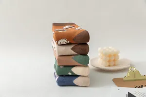Close-up detail of folded thick winter socks with cute cartoon animal pattern and loop pile.