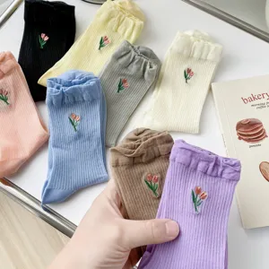 Detail view of women ribbed mid-calf socks with cute tulip embroidery in assorted colors.