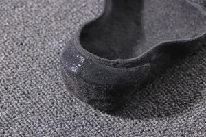 Close-up detail of mens invisible boat sock heel with anti-slip silicone grip in black.